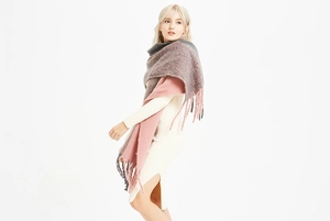 Détail d'une écharpe en grosse maille avec longues franges et design rose et gris