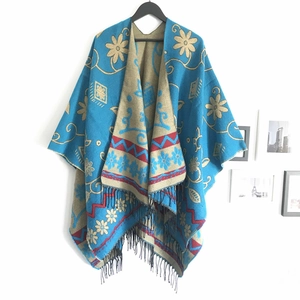 Detail of blue and khaki sunflower shawl with geometric patterns and black tassels