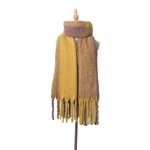 Détail d'une écharpe d'hiver épaisse en tricot jaune et marron avec franges torsadées