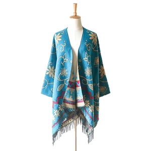 Ethnic knit shawl with floral patterns, blue turquoise fabric and black tassel details