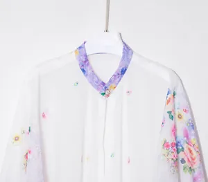 Detail of floral chiffon sun protection shirt with purple flower patterns and buttons