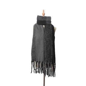 Détail d'une écharpe en maille color-block avec de longues franges noires et grises