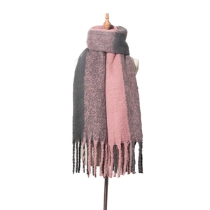 Détail du tissu épais en tricot rose et gris foncé de l'écharpe avec de longs franges