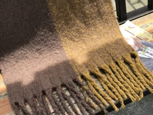 Gros plan détaillé des franges épaisses et du tricot bicolore texturé sur l'écharpe chaude