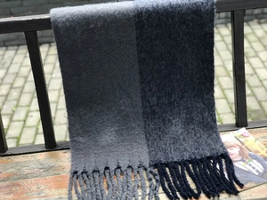 Gros plan sur une écharpe en maille bicolore avec des pompons doux et texture veloutée