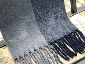 Détail d'une écharpe en maille épaisse avec bicolore gris et de longues franges