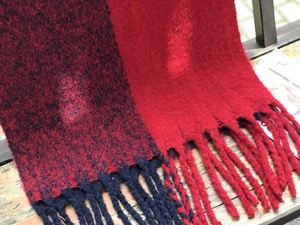 Gros plan de la texture de l'écharpe en maille rouge et noire avec de gros glands