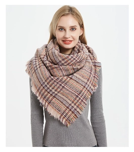 Close-up of thick plaid shawl with orange and purple knit texture and fringe edge