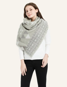Detail of green and grey scarf featuring geometric triangles and floral patterns with fringe