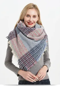 Detailed shot of thick plaid scarf with tassels on grey base with blue and orange stripes