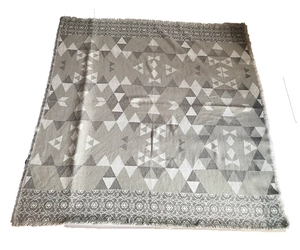 Detail of geometric knit pattern with vintage floral accents and fringe edges shawl