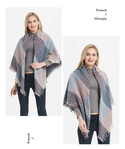 Détail d'une écharpe à carreaux gris, bleu et orange avec de longues franges pour femme