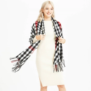 Plaid cashmere-like scarf with fringe detail shown on model for autumn and winter warmth