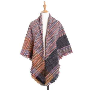 Close-up of colorful striped woven scarf with fine fringe edges on a mannequin