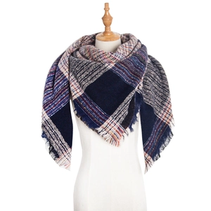 Detail view of large checkered knit shawl featuring fringe trim and soft vintage patterns
