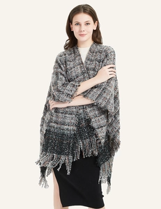 Detail of tweed knit shawl showing grey texture and stylish fringe hemline design