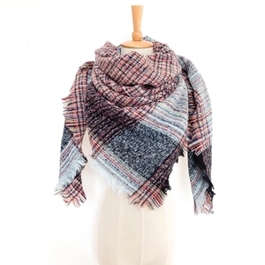 Close-up of thick plaid knit scarf featuring pastel color blocks and soft fringe detail