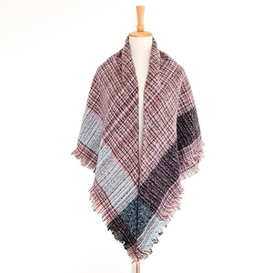 Detail of a thick plaid shawl with fringe edges on a mannequin for warmth
