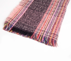 Close-up of striped knit scarf with long pink tassels and multicolored woven texture