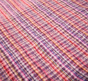 Close-up of thick multi-color tweed woven fabric texture with pink and blue yarns