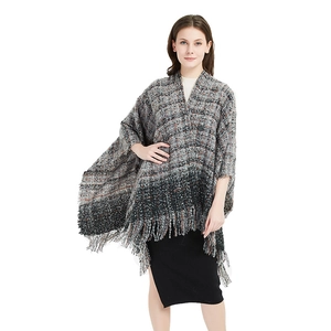 Women's thick plaid knit shawl poncho with grey checkered pattern and long fringe trim