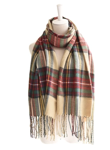 Detail shot of the soft fringe and multicolor plaid pattern on a winter blanket shawl