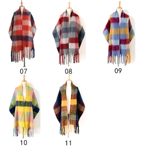 Detail showing five assorted plaid scarves with fringe on mannequins in multiple colors