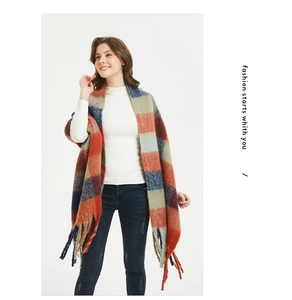 Detail of soft thick plaid scarf with orange and blue squares and long tassels