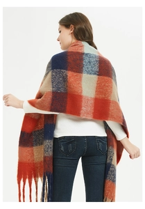 Macro shot of oversized multi-color plaid shawl with tassel hem and soft wool-like texture