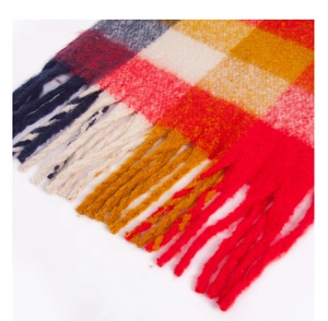 Close-up of thick plaid scarf featuring vibrant colorful checks and long tassel fringe details
