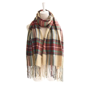 Classic plaid winter scarf with fringe in red green and yellow on a white background