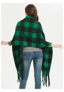 Back view of a thick green and black plaid shawl with long fringe tassels