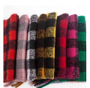 Close-up of thick buffalo plaid scarves in various colors with soft fringe detail