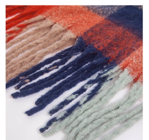 Macro detail of colorful tassels and thick knit texture on a plaid winter scarf