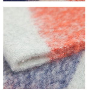Detailed close-up of fluffy mohair-style plaid scarf with rich knit texture and vibrant colors