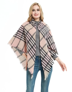 Detail of pink plaid triangle scarf with tassel edge on a female model