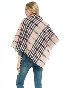 Detail of plaid knit poncho with long tassels in pink and beige checkers for autumn winter