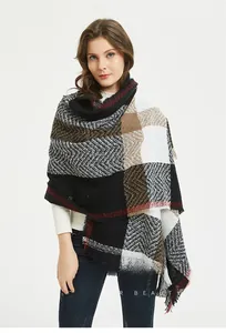 Close-up of thick herringbone plaid scarf with tassels and red stripe accents