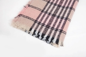 Detail of soft plaid scarf showing pink and beige checkered weave with fringe edges