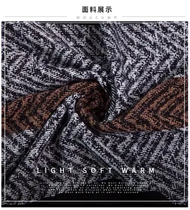Macro shot of thick herringbone knit fabric showing grey and brown woven textures
