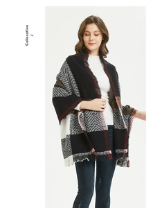 Detail of oversized plaid scarf with tassels in black white red herringbone pattern