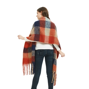 Thick oversized checkered scarf with orange and blue plaid pattern and fringe details