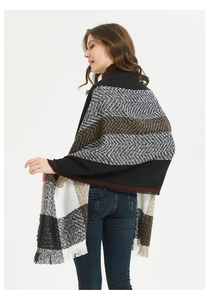 Detailed close-up of thick winter shawl featuring geometric patterns and soft fringe trim