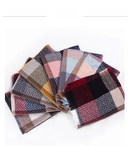 Detailed close-up of multiple plaid scarves with various color patterns and soft fringe edges