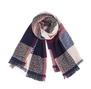 Macro detail of navy and burgundy plaid scarf showing herringbone weave and soft fringes