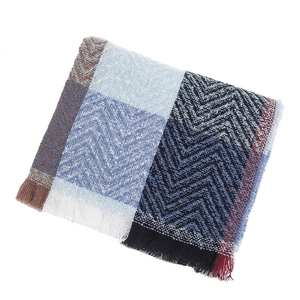 Close-up of winter thick knit scarf featuring plaid pattern and fringe tassels detailing
