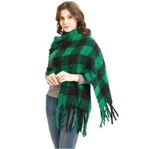 Green and black checkered knit scarf with tassels worn by model for winter fashion style