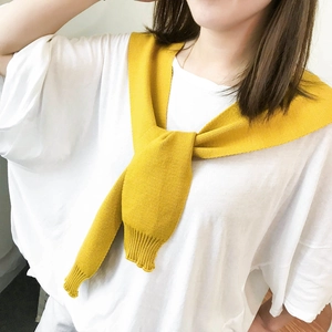 Vibrant yellow knitted shawl wrap with ribbed cuffs worn casually over a white t-shirt