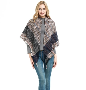 Detalle del poncho de cuadros azul y beige con bordes de flecos muy suaves