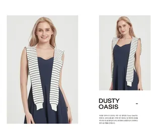 Detail showing knit striped shawl draped over a navy blue V-neck midi dress on model